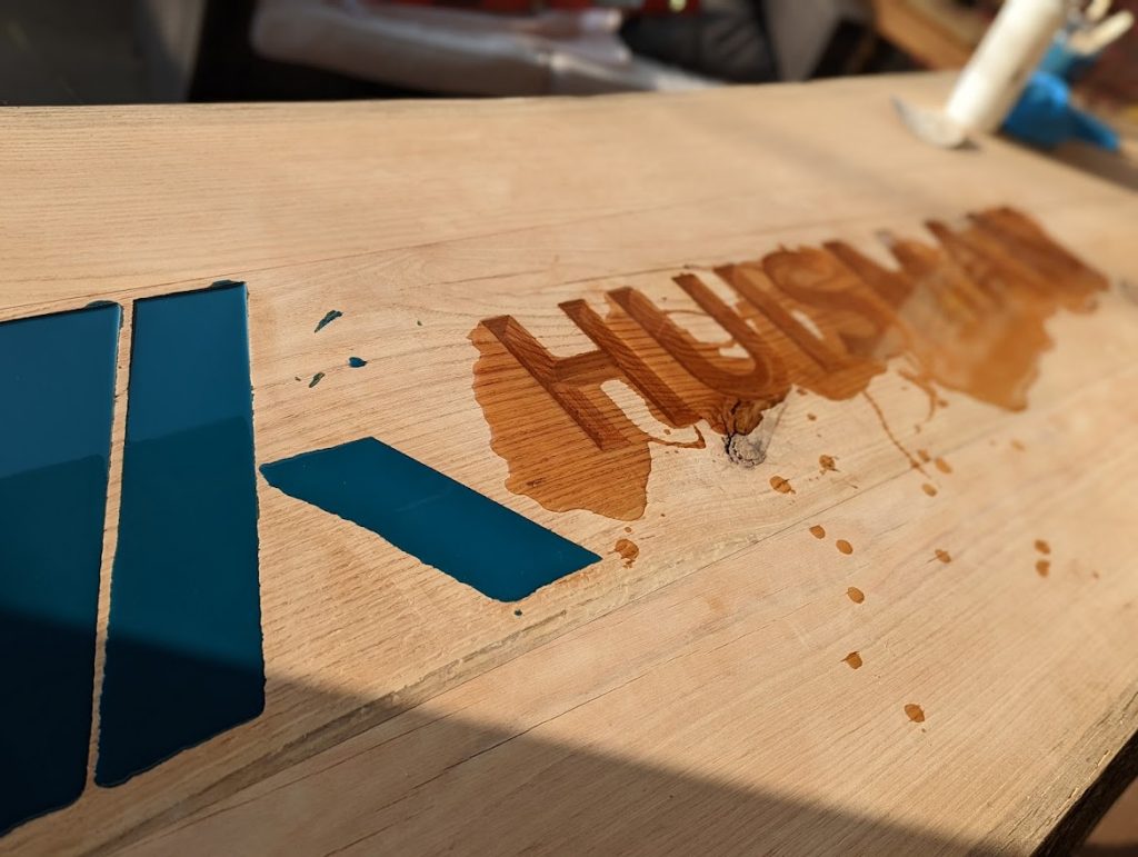 Logo ingieten met epoxy in houten vergadertafel