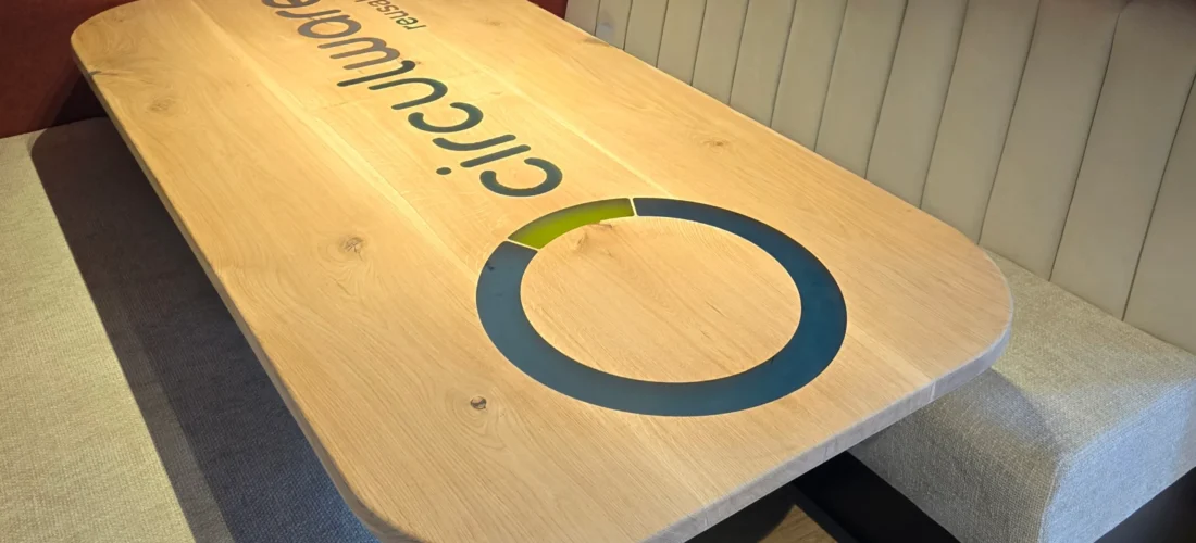 Tafel met groot logo erop van Circulware en zitbankjes