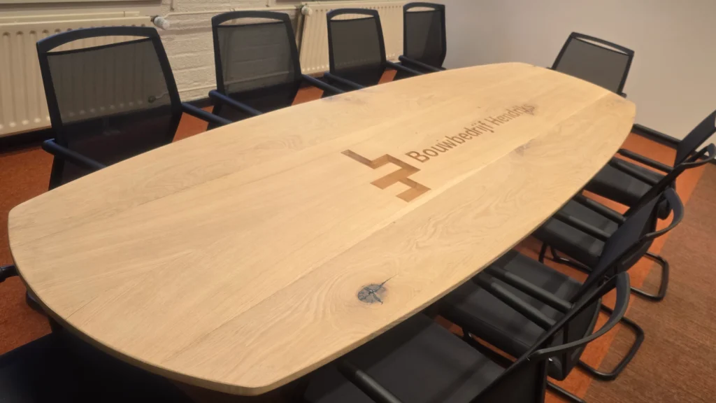 Ovale vergadertafel met logo bouwbedrijf Hendriks