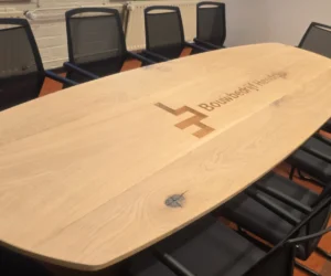 Ovale vergadertafel met logo bouwbedrijf Hendriks