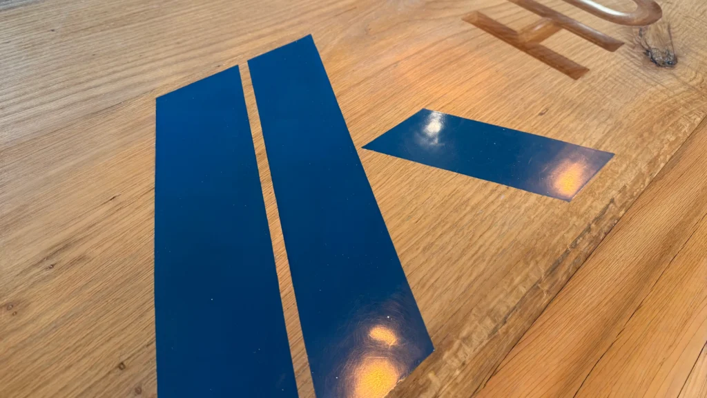 Detail van houten tafel met logo gegoten in epoxy