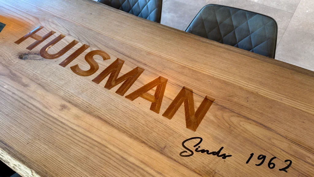 Tafel met logo – detail van epoxy inleg in tafelblad