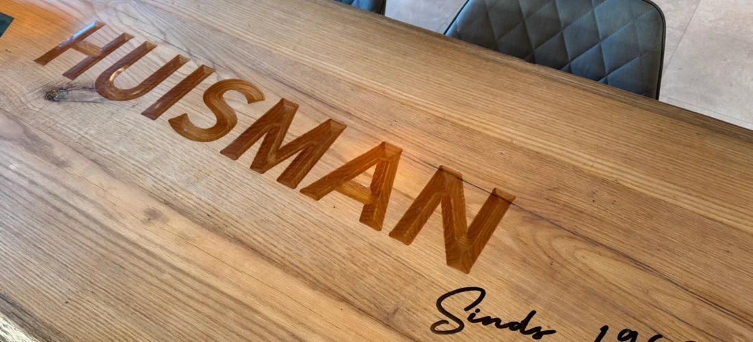 Tafel met logo – detail van epoxy inleg in tafelblad